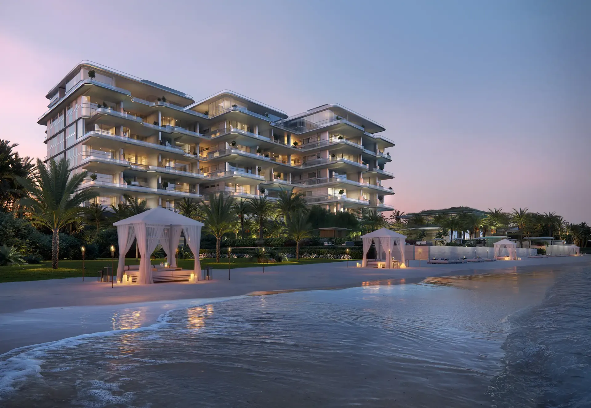 Orla Dorchester Collection – pastatas prie paplūdimio su palapinėmis saulėlydžio metu
